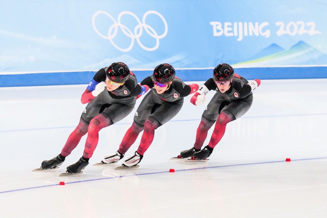 Women's long track speed skaters skating in team pursuit