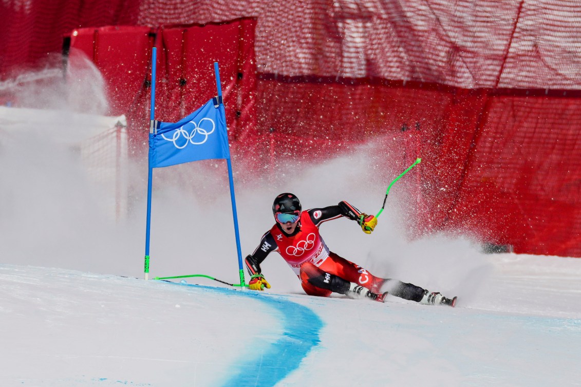 Trevor Philp leans low while skiing past a gate