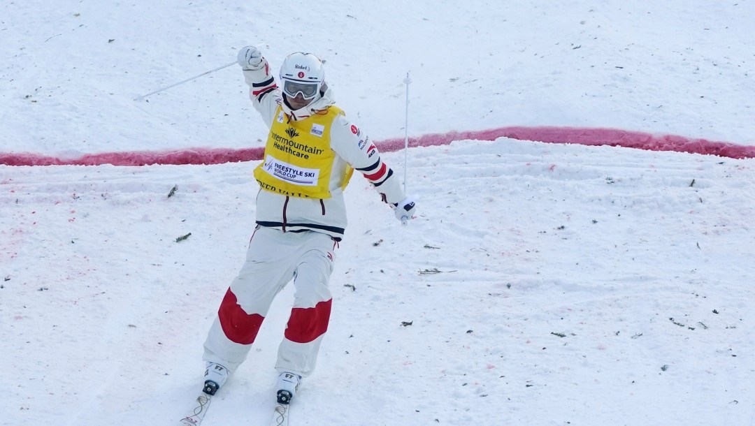 Team Canada's Mikaël Kingsbury celebrates with his hands up after completing a mogul run