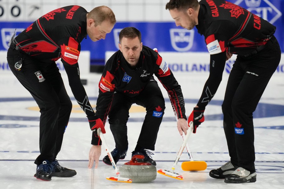 Canada skip Brad Gushue, center, delivers a stone against the Czech Republic during the men's world curling championships Saturday, April 2, 2022, in Las Vegas. (AP Photo/John Locher)