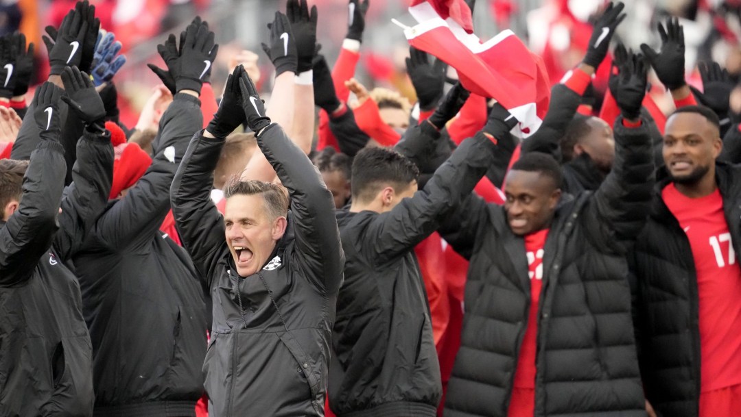 John Herdman and his players clap their hands above their heads