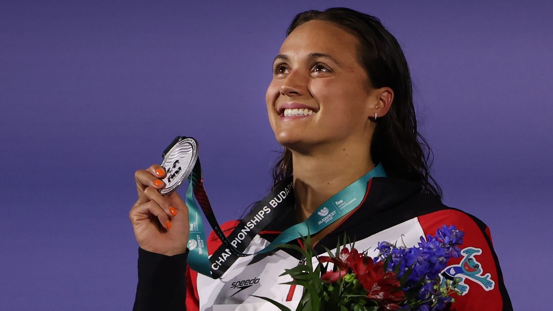 Kylie Masse holds her silver medal on the podium as she looks to the sky