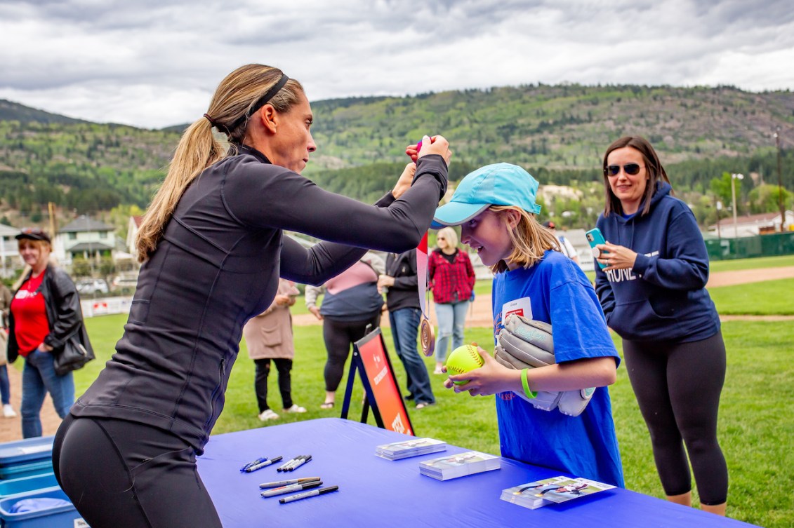 Lauren Regula puts her Olympic bronze medal around the neck of a young fan 