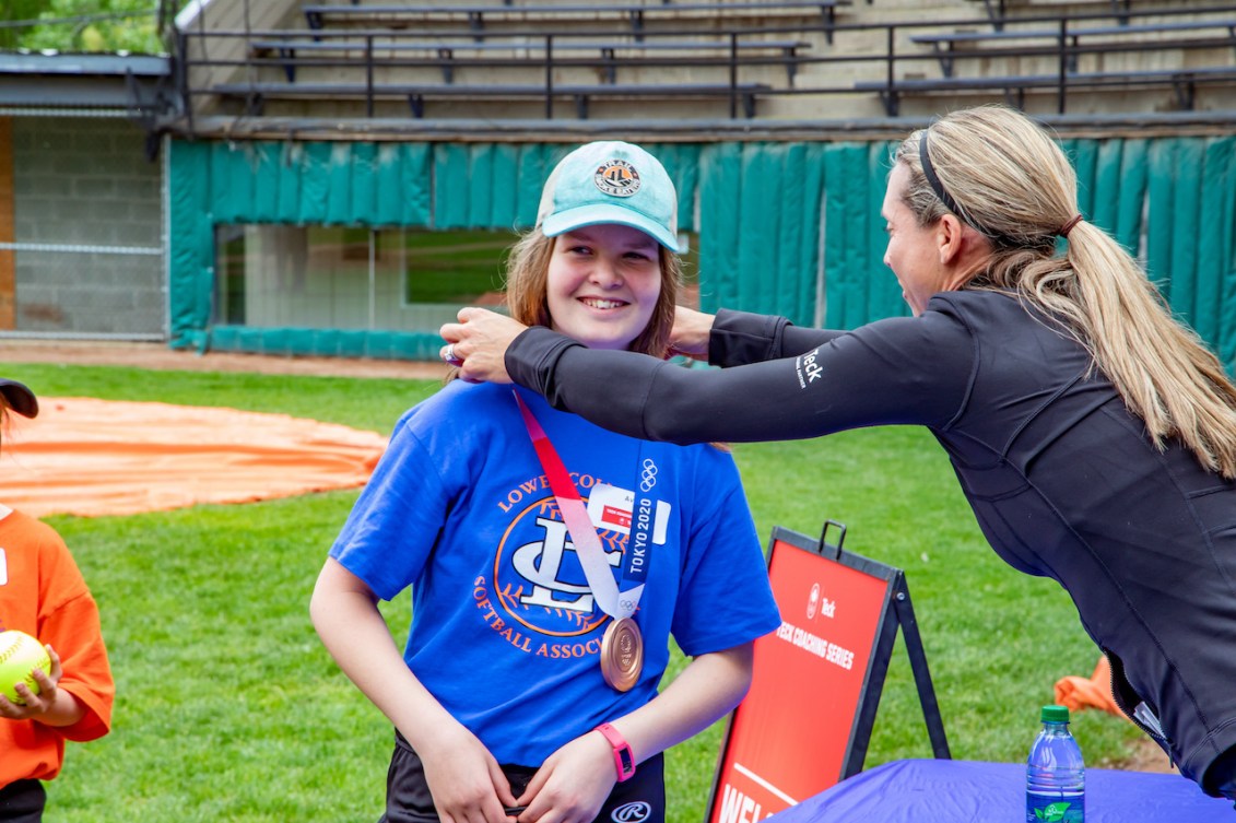 Lauren Regula puts her Olympic bronze medal around the neck of a young fan