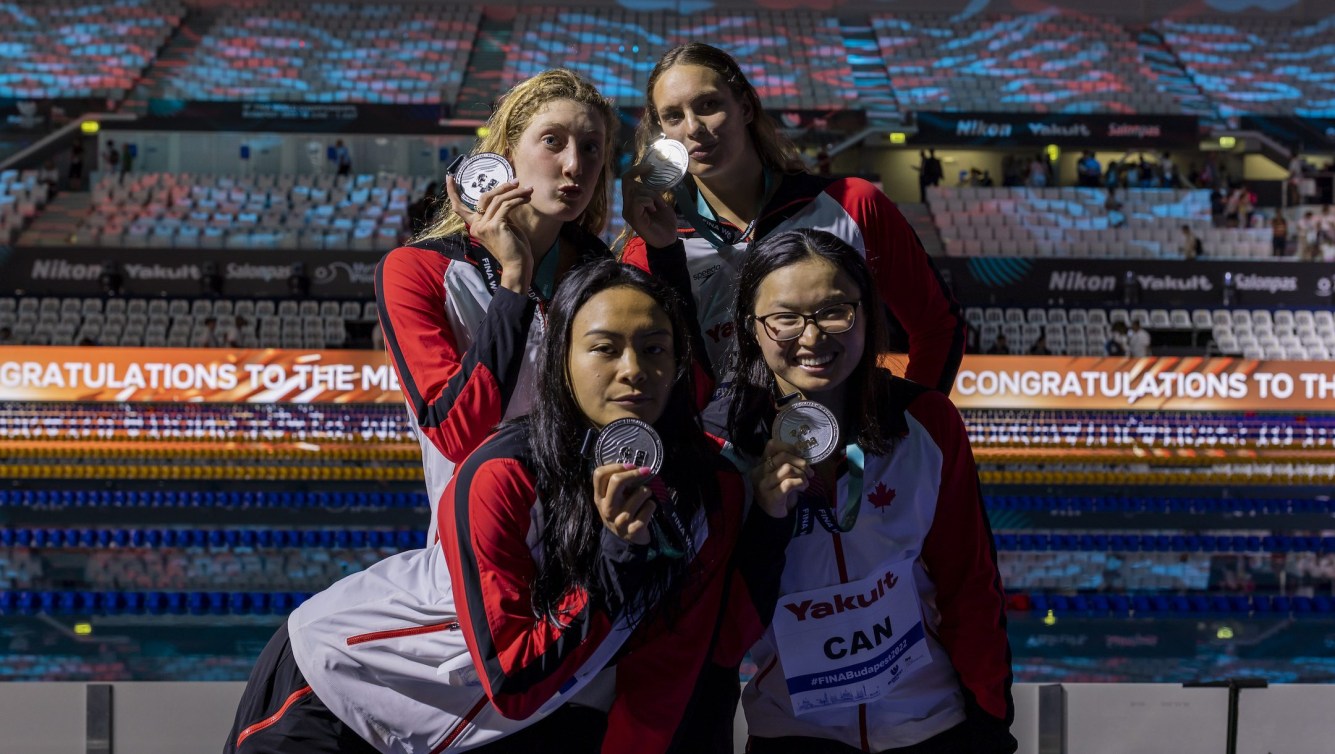 Four Canadian swimmers pose with their silver medals