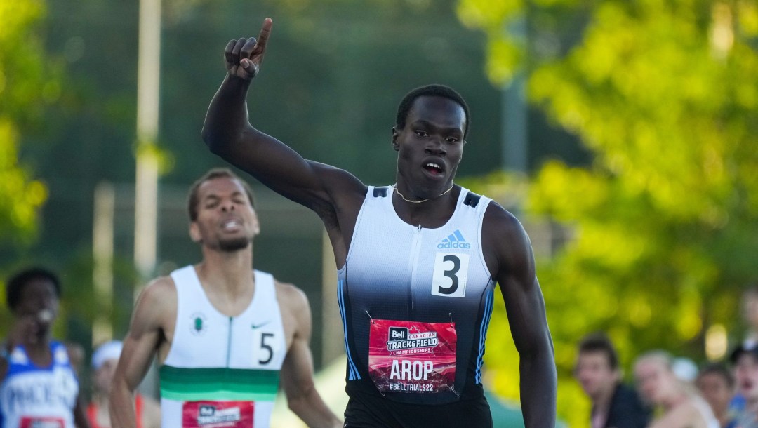 Marco Arop raises his finger to show number one as he crosses the finish line