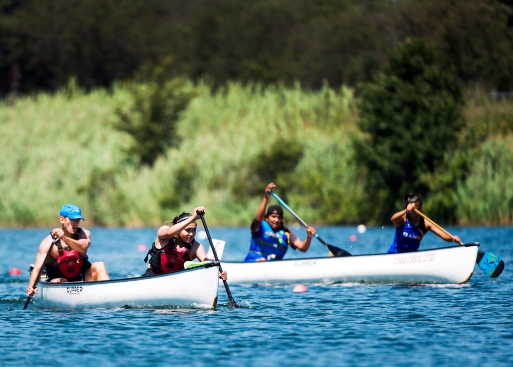 Two traditional canoes race each other on a lake 