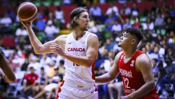 Kelly Olynyk holds the ball against a Panama opponent,