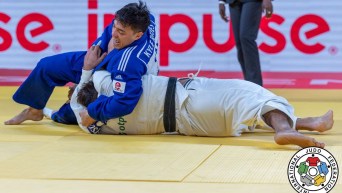 Kyle Reyes pins an opponent to the mat in a judo match