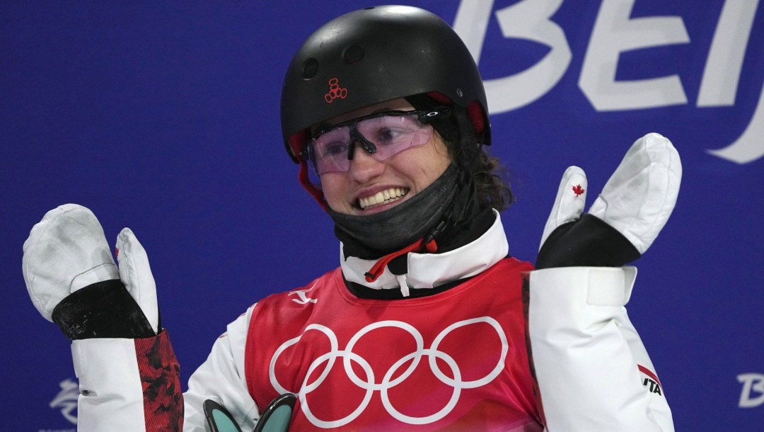 Marion Thenault smiles and waves her hands as she waits for her scores