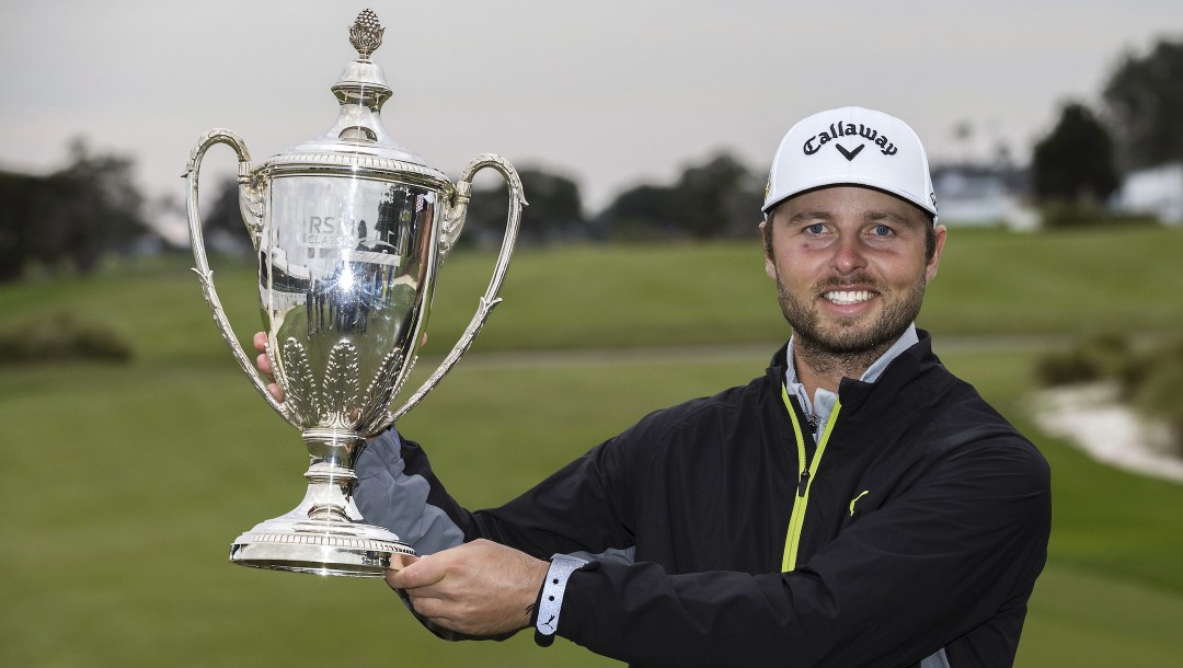 Adam Svensson, of Canada, holds the winning trophy after the final round of the RSM Classic golf tournament, Sunday, Nov. 20, 2022, in St. Simons Island, Ga. (AP Photo/Stephen B. Morton)