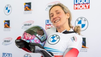 Mirela Rahneva holds her helmet in the finish area and smiles for the camera