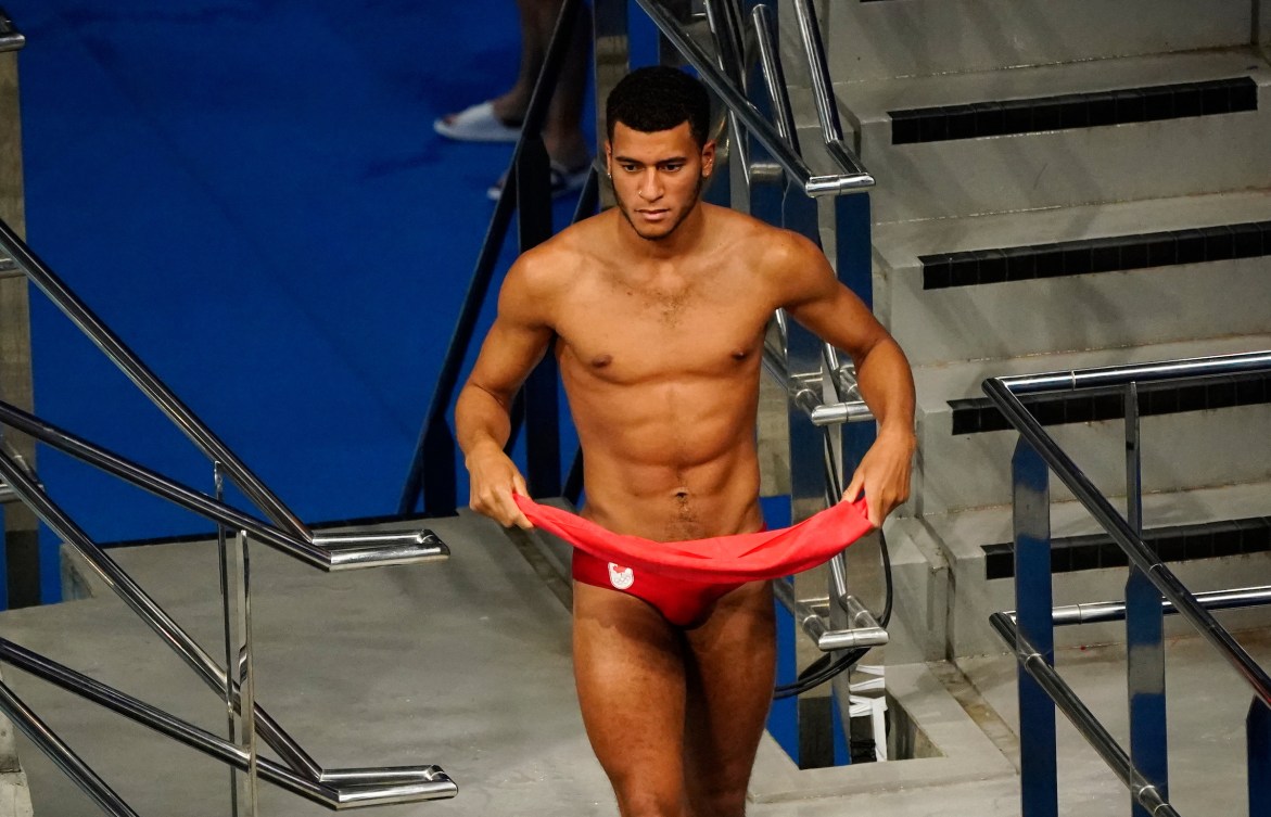 Cedric Fofana walks on the pool deck with towel in hand 