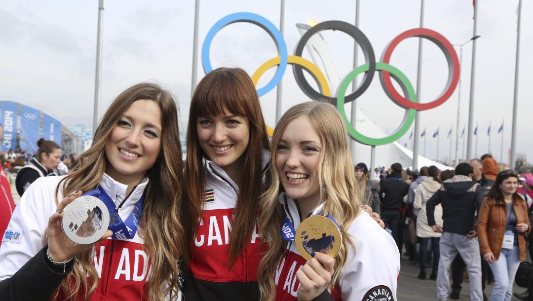 The Dufour-Lapointe sisters pose in front of the Olympic rings