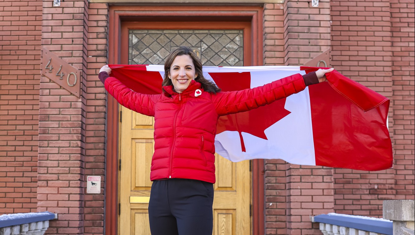 Lisa Weagle poses with a Canadian flag outside the Ottawa Curling Club