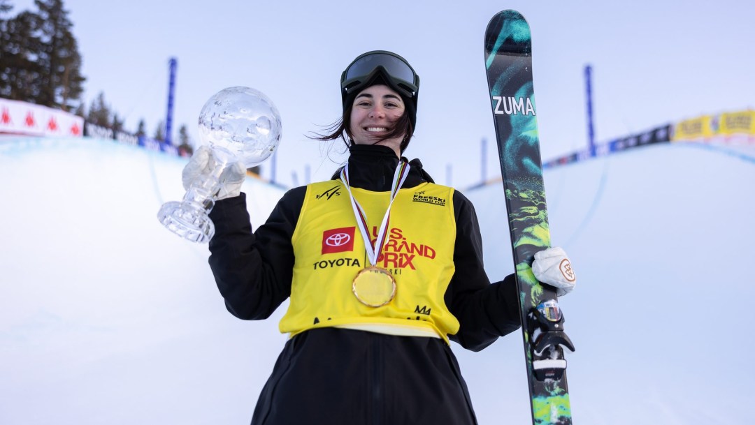 Rachael Karker poses with a crystal globe and her skis