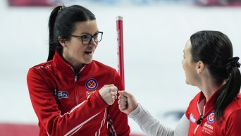 Kerri Einarson and Val Sweeting tap fists while smiling