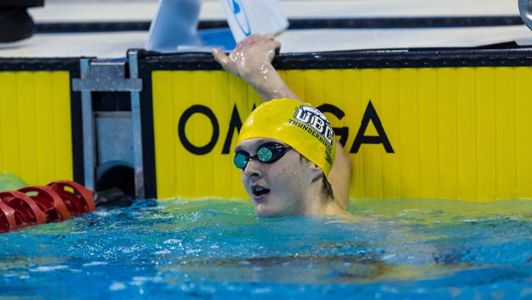 Hugh McNeill wears a yellow swim cap as he holds onto the wall in the pool