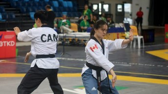 Jinsu Ha and Valerie Ho perform arm movements in poomsae taekwondo competition