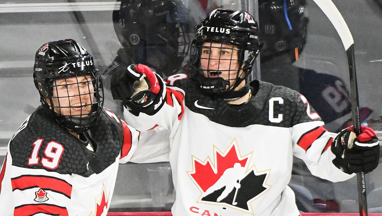 Marie-Philip Poulin points at a teammate after scoring a goal