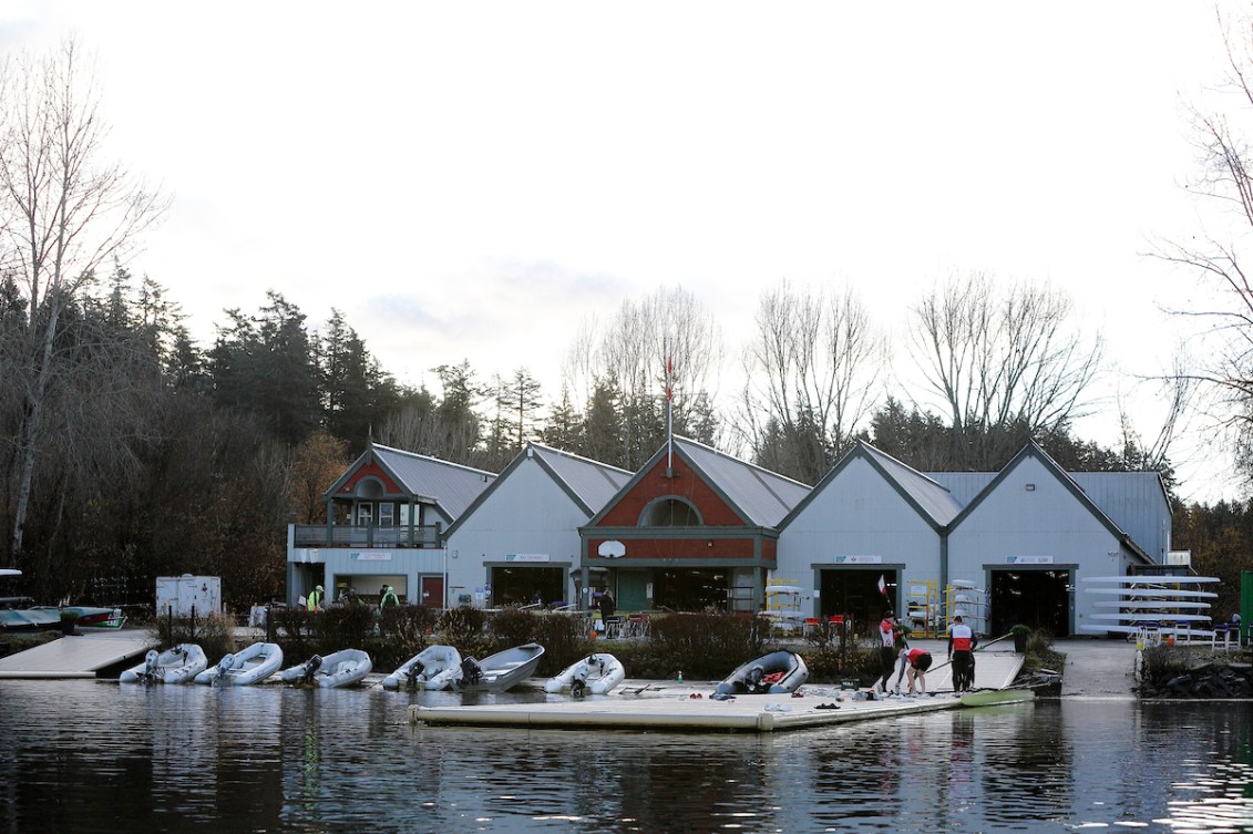 Seven coach boats with gas outboard motors are lined up against a dock.