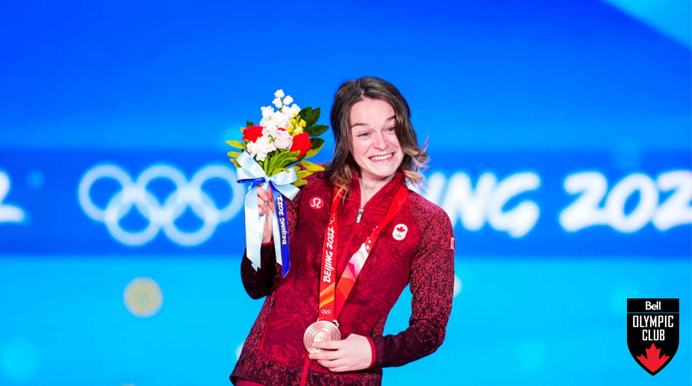 Kim Boutin poses with a bronze medal and flowers at the Bejing 2022 olympics