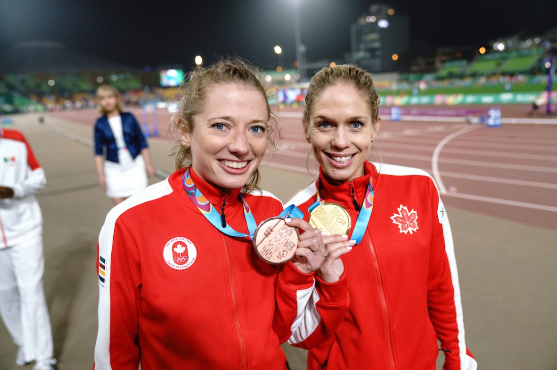 Rachel Cliffe, left, and Natasha Wodak of Canada show off their medals after coming first and third in the women's 10,000m race at the Lima 2019 Pan American Games
