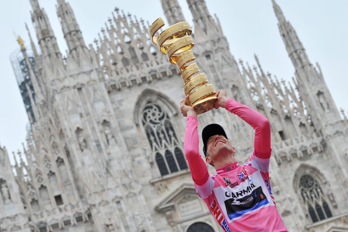 Ryder Hesjedal levanta el trofeo del Giro de Italia por encima de su cabeza frente a una gran catedral