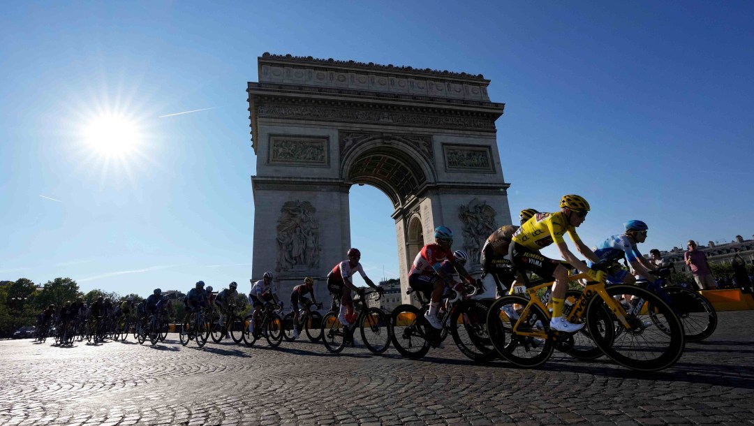 Many road cyclists race past the Arc de Triomphe