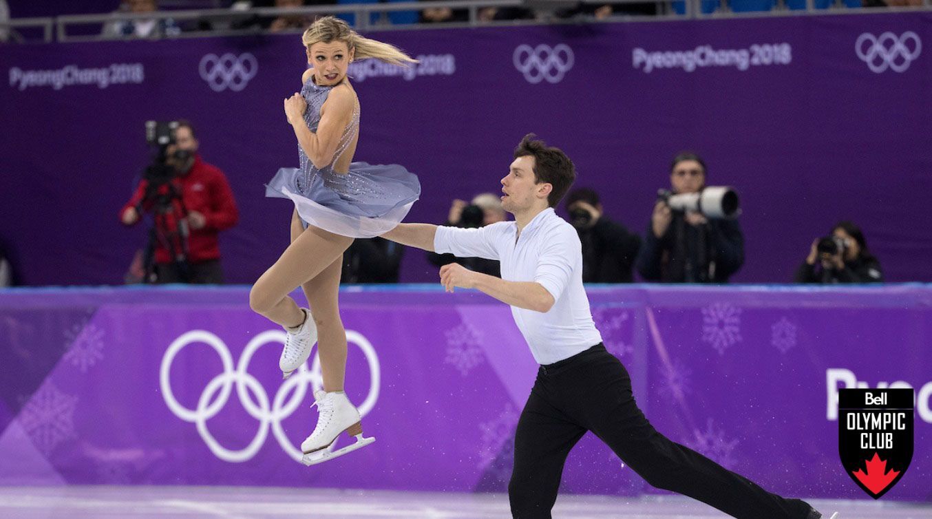 Female skater in air as male skater skates on ice