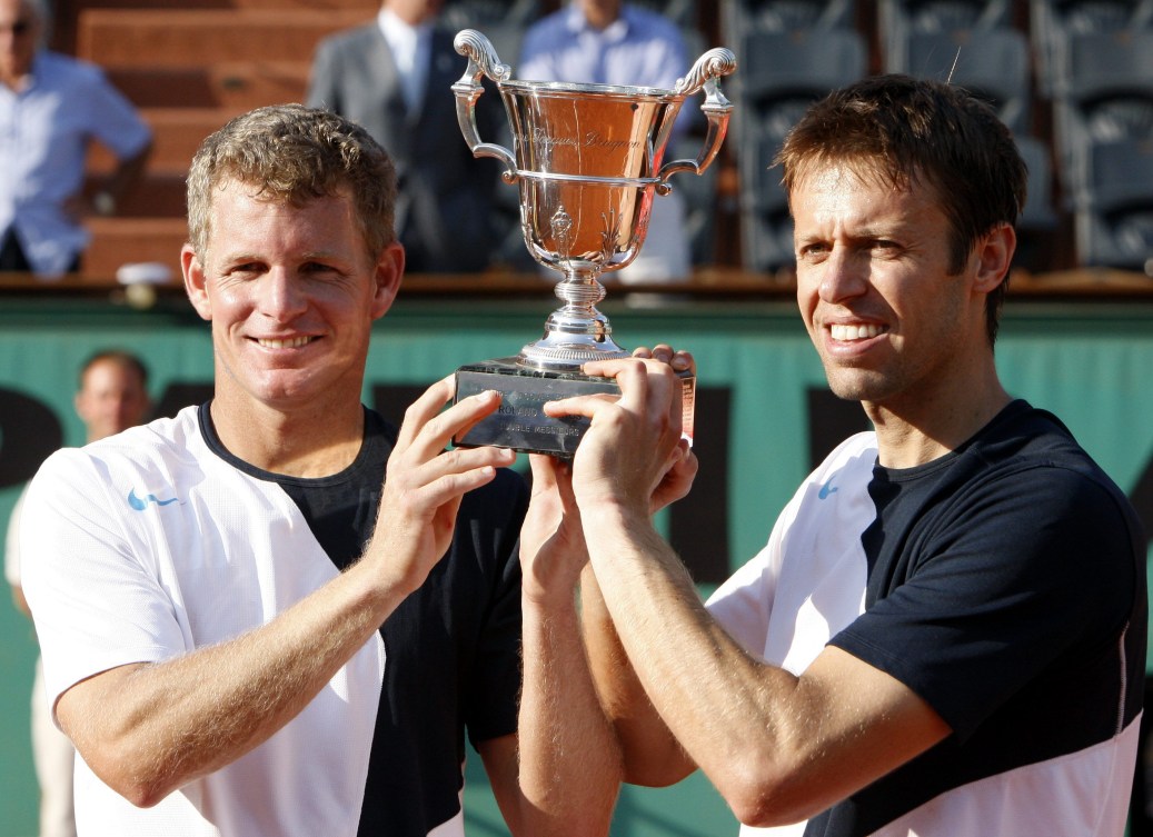 Daniel Nestor and teammate Mark Knowles hold up their French Open doubles trophy