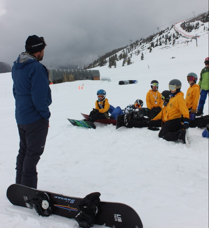 Liam Gill's father Lance speaks to a group of young Indigenous snowboarders on snow