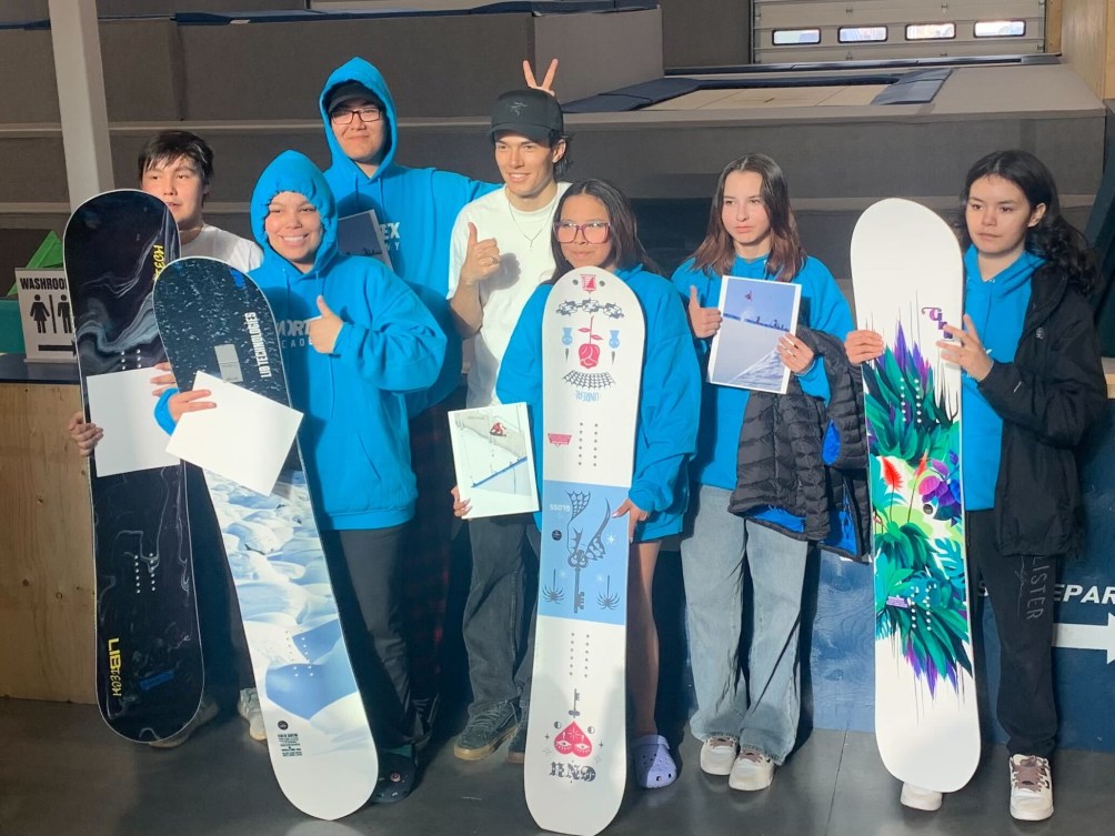 Six young Indigenous snowboarders pose with the boards they were gifted