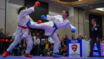 Melissa Bratic kicks an opponent in the chest in a karate bout