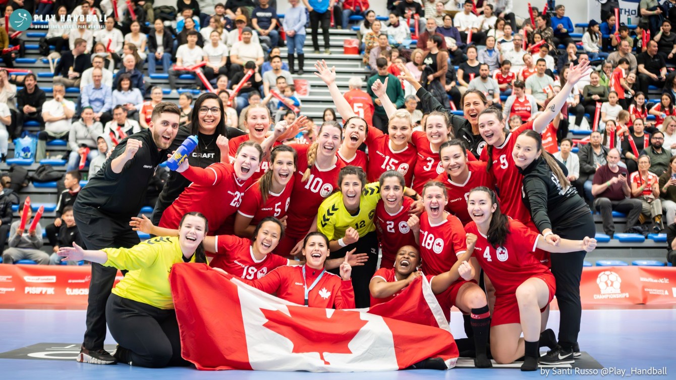 Canadian handball players pose with the Canadian flag on court