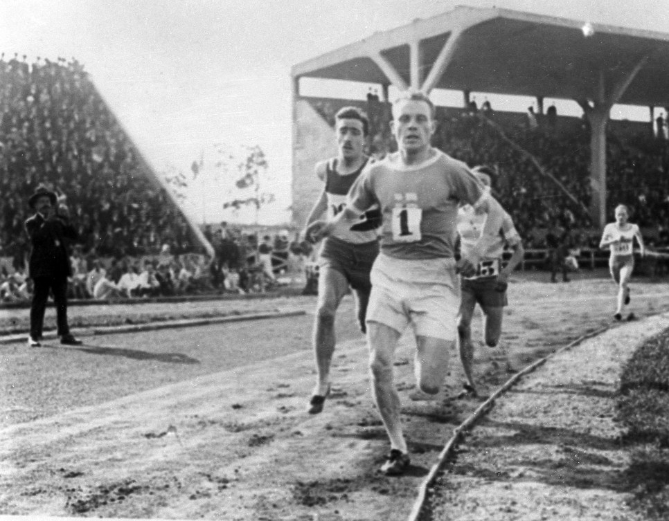 Black and white photo of Paavo Nurmi wearing bib one at the front of a group of runners 