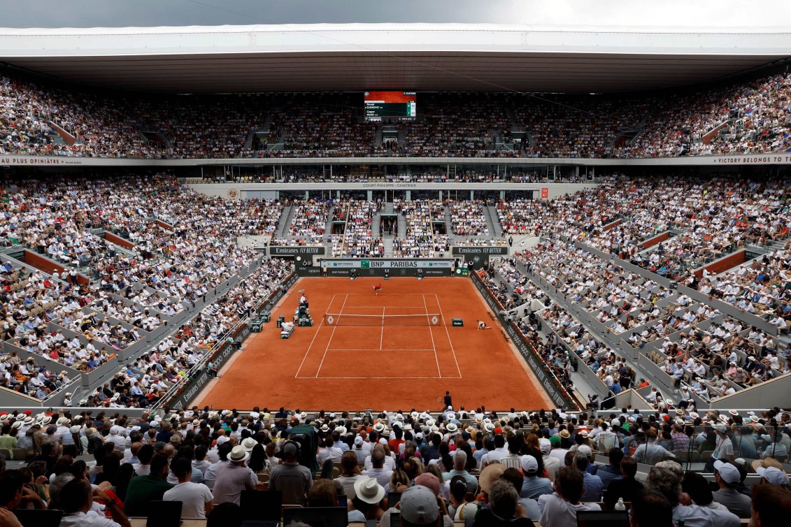 Tennis court surrounded by stadium of fans at Roland Garros Stadium