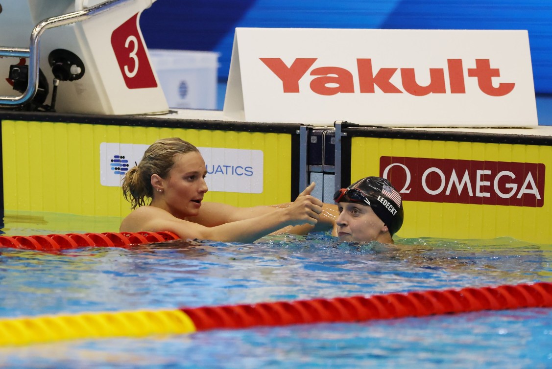 Summer McIntosh gives a thumbs up as she hangs off the lane rope by the pool wall 