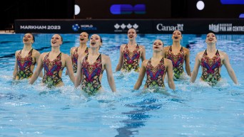 Eight artistic swimmers in the water.