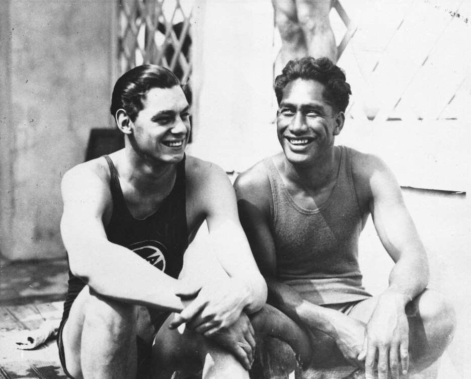 Johnny Weissmuller and Duke Kahanamoku sit side by side in a black and white photo 