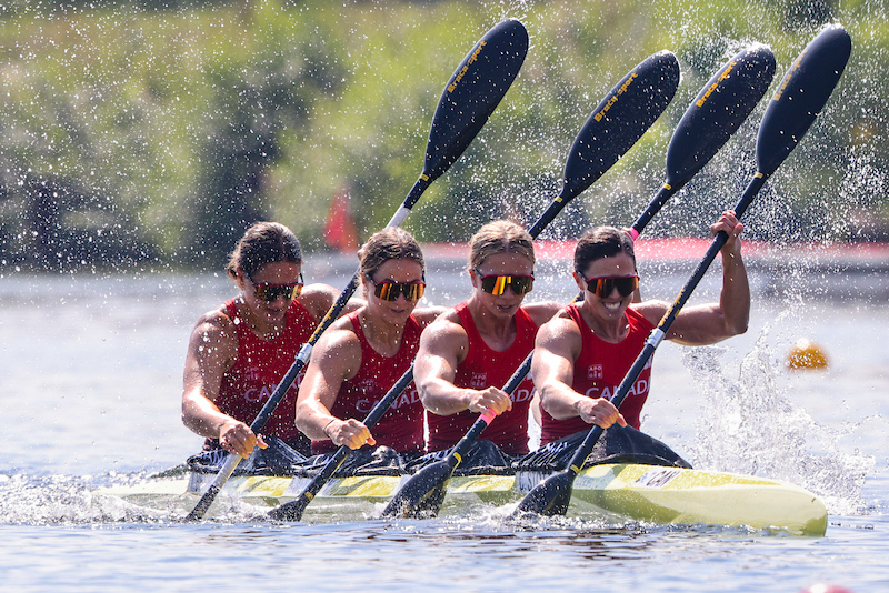 Four women kaykers paddle their boat 