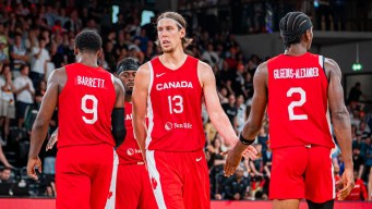 Canadian basketball players shake hands with each other during a game