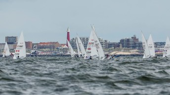 Multiple sail boats compete on a course in the Netherlands