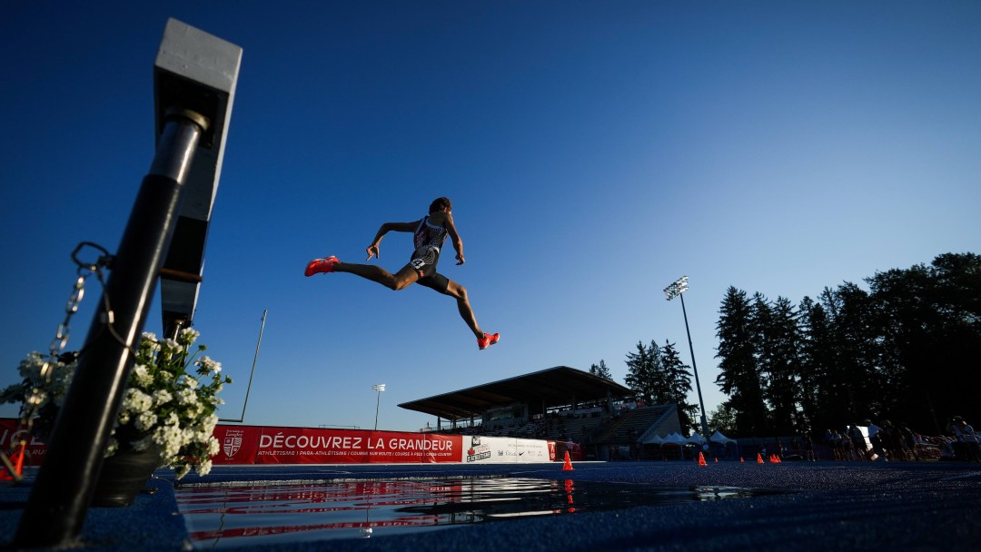Jean-Simon Desgagnes leaps over a water pit during the steeplechase event at the national championships.