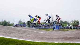 Ryan Tougas catches air with other athletes during a BMX race