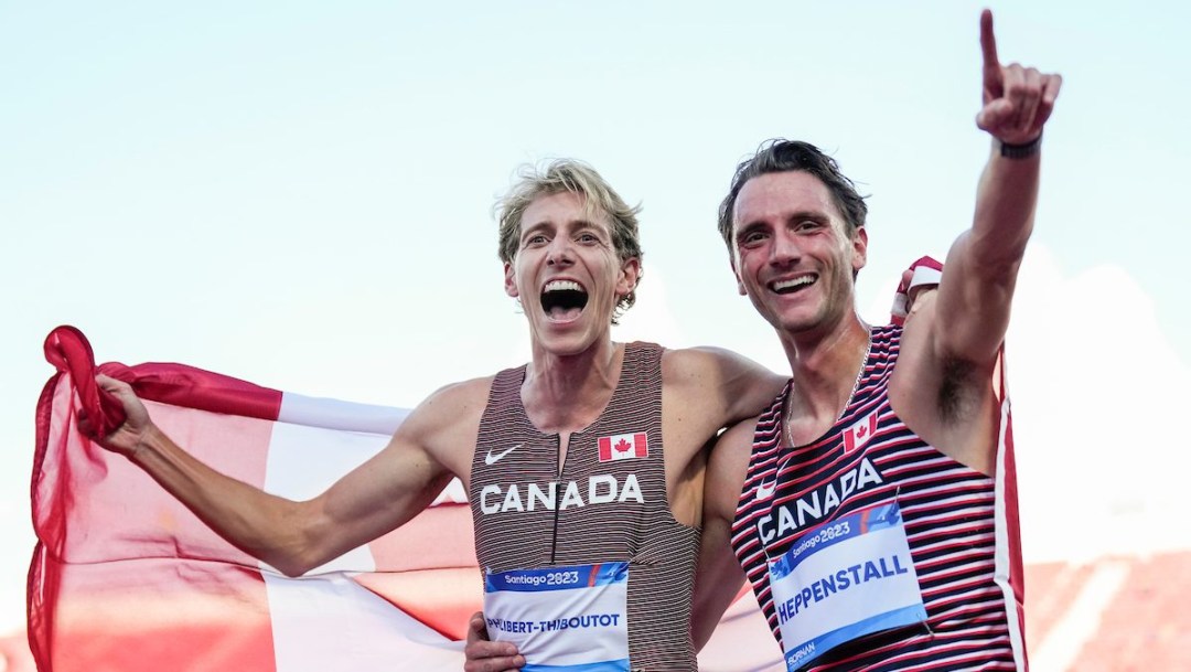 Charles Philibert-Thiboutot and Robert Heppenstall celebrate while draped in a Canadian flag