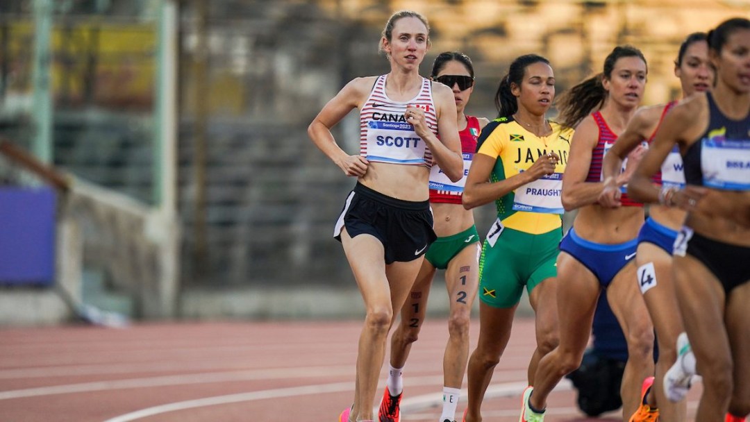 Briana Scott runs at the edge of a pack of runners on the track