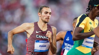 Stephen Evans runs on the track close behind a Jamaican athlete