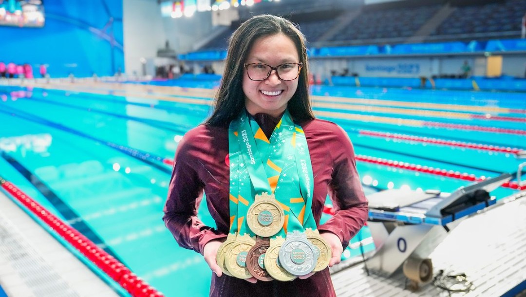 Maggie Mac Neil poses with seven medals around her neck