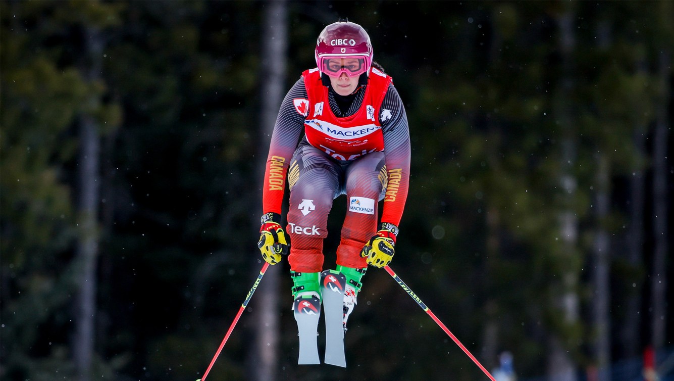 A female ski cross racer jumps for Team Canada